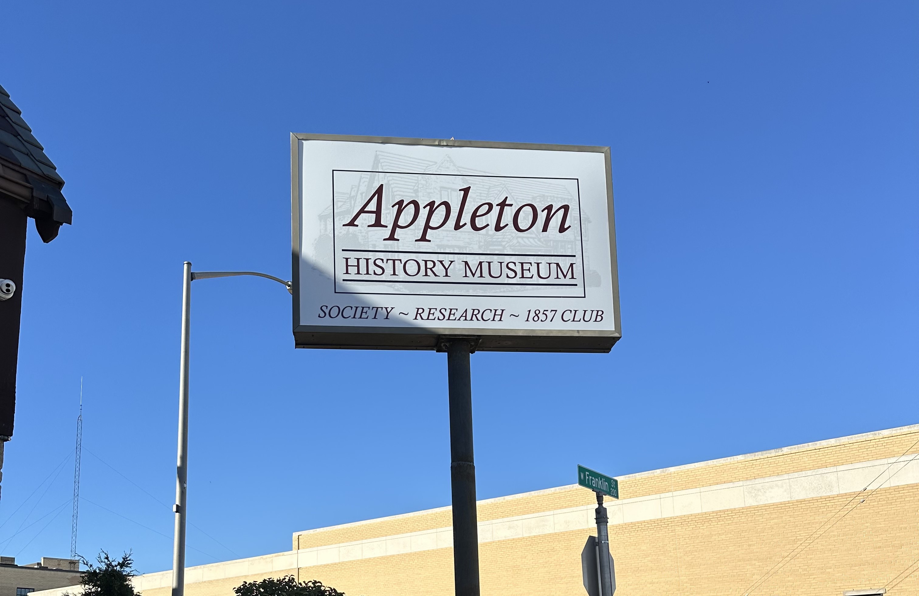 Appleton History Museum cabinet pole sign against a clear blue sky