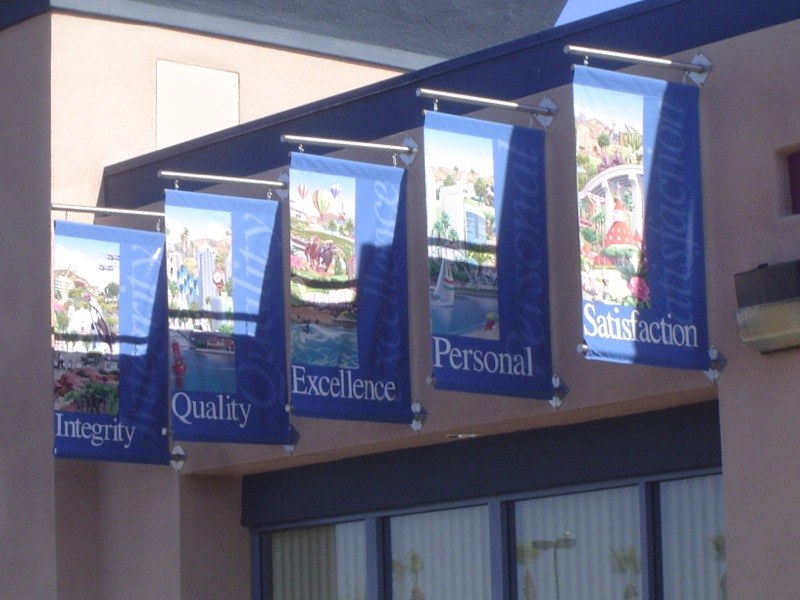 Custom outdoor banner flag mounted near a storefront
