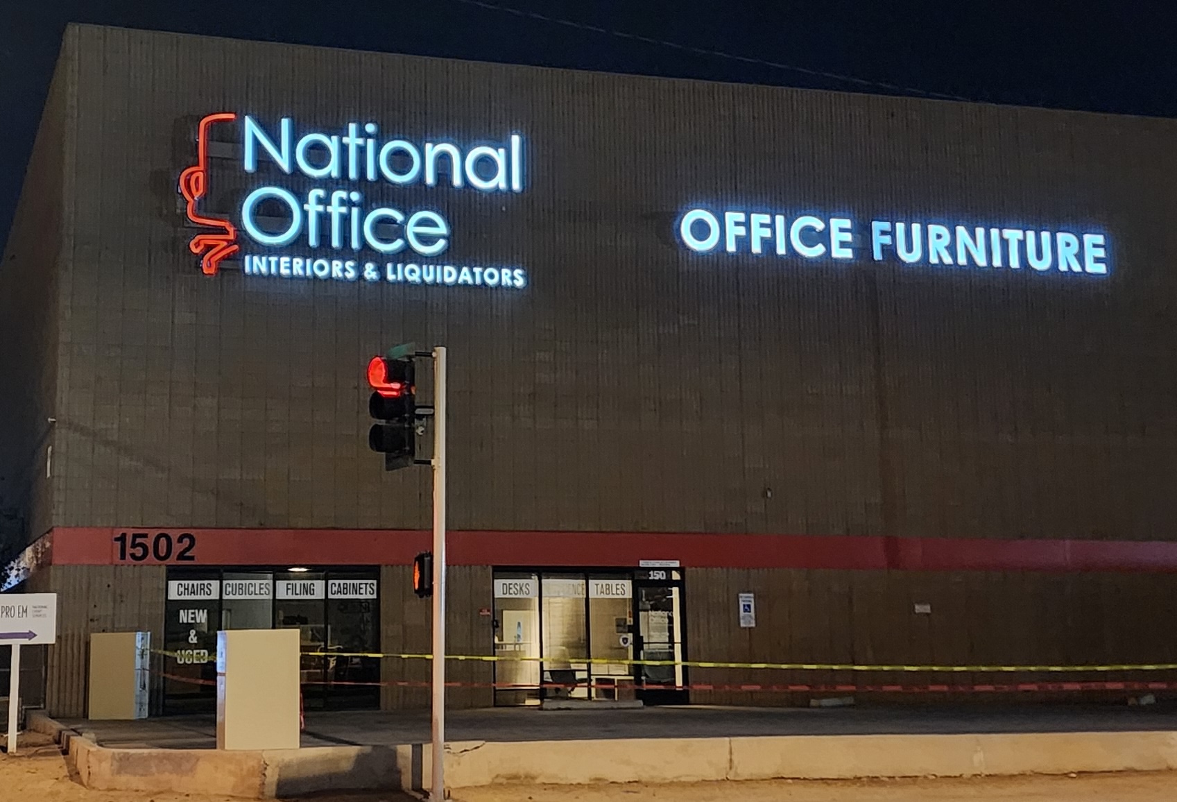 Illuminated exterior business sign visible after dark