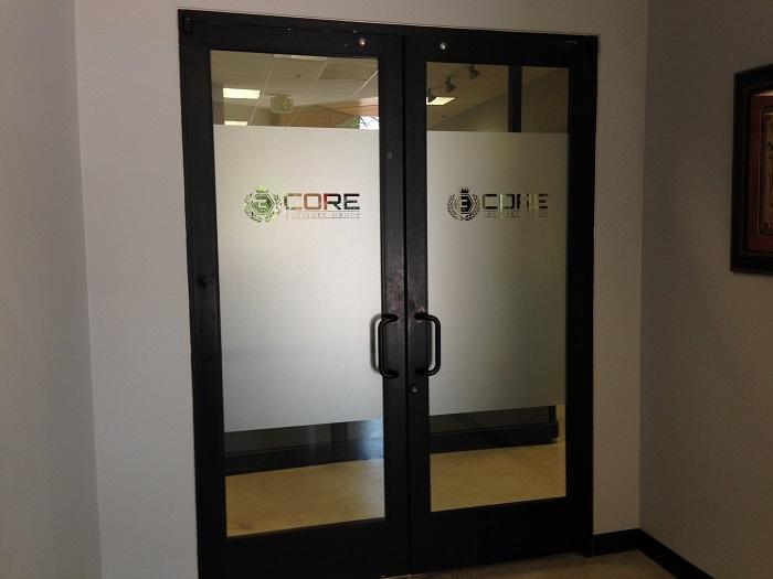 Business entry door enhanced with custom window graphics and lettering